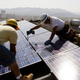 Workers install solar photovoltaic panels on the roof of a home in Glendale, California in March, 2010. Image: AP Photo/Reed Saxon, File